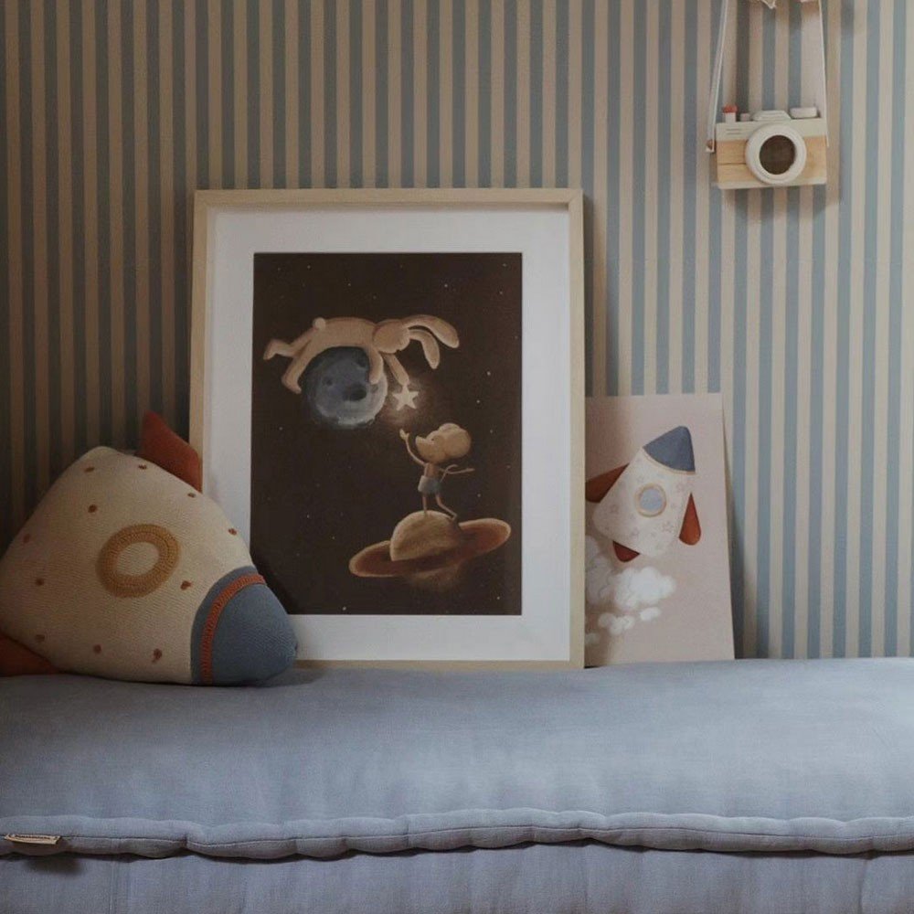 3. Beige and blue striped wallpaper with framed space-themed art and rocket cushion on a bench