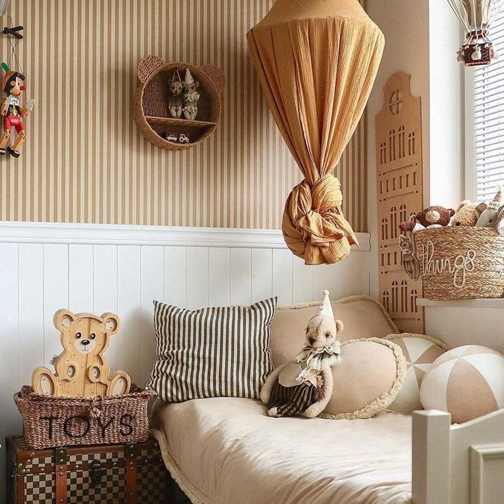 5. Children's room with beige and brown striped wallpaper, featuring a bed with a canopy, plush toys, and decorative elements like a toy bear and striped pillows