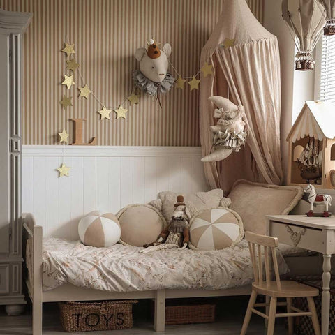 1. Children's room with beige and brown striped wallpaper, featuring a bed with decorative pillows, a canopy, and whimsical decor elements like star garlands and plush toys