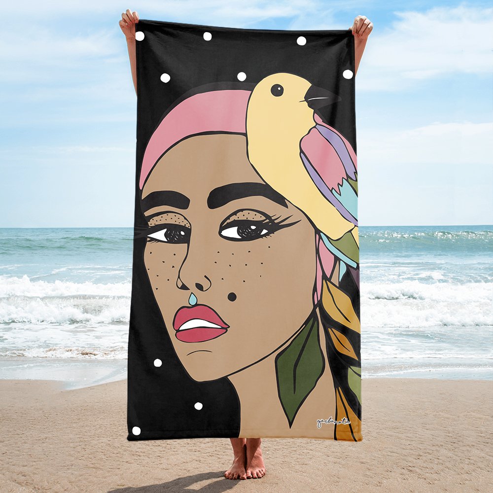 1. Women's black Towel Siuzana by Garbanota with hand-drawn artwork, held on a beach
