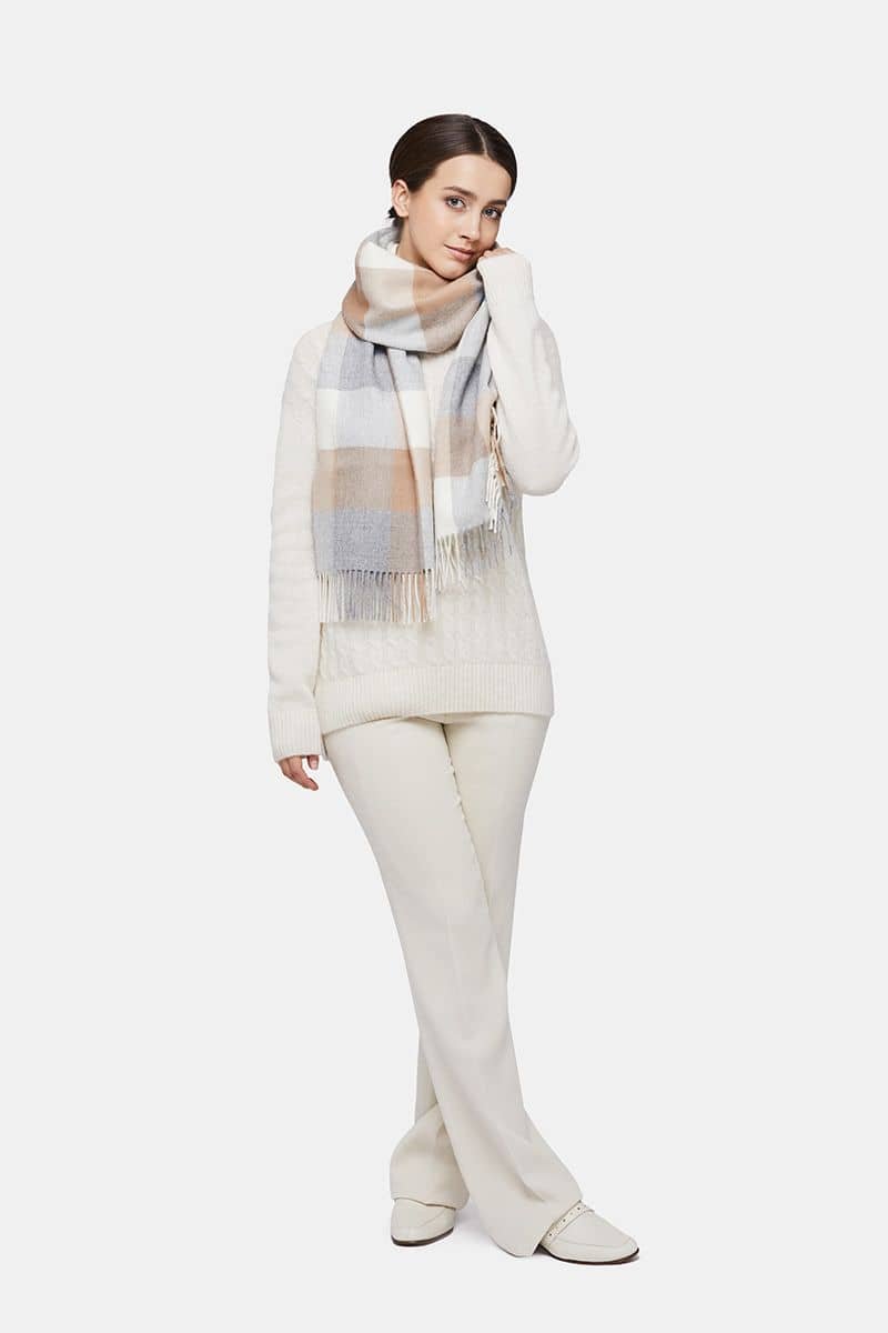 1. Women's natural baby alpaca wool check scarf in gold and grey, worn by model in lifestyle setting