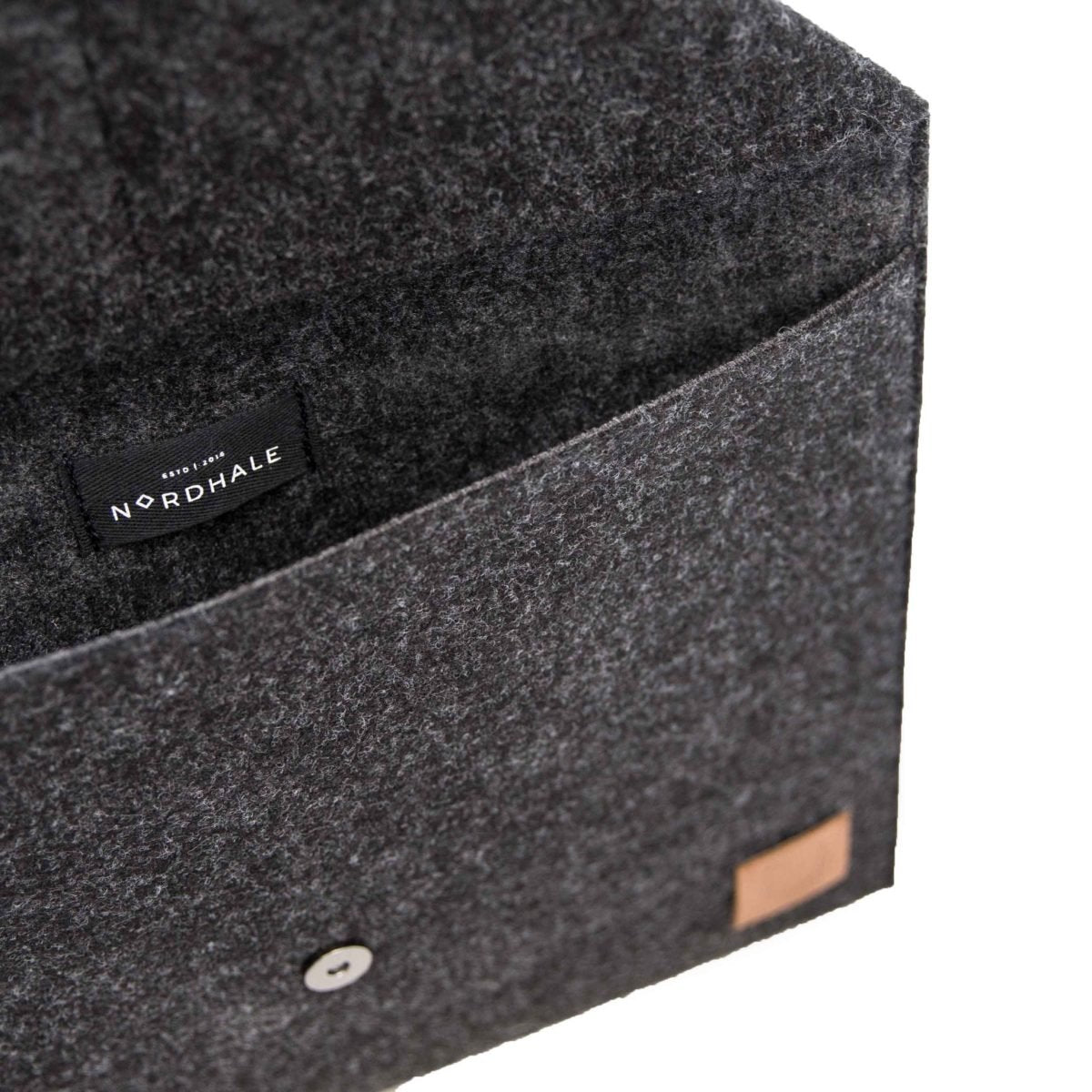 5. Close-up of Nordhale Skive black clutch and laptop case showing interior and brand label