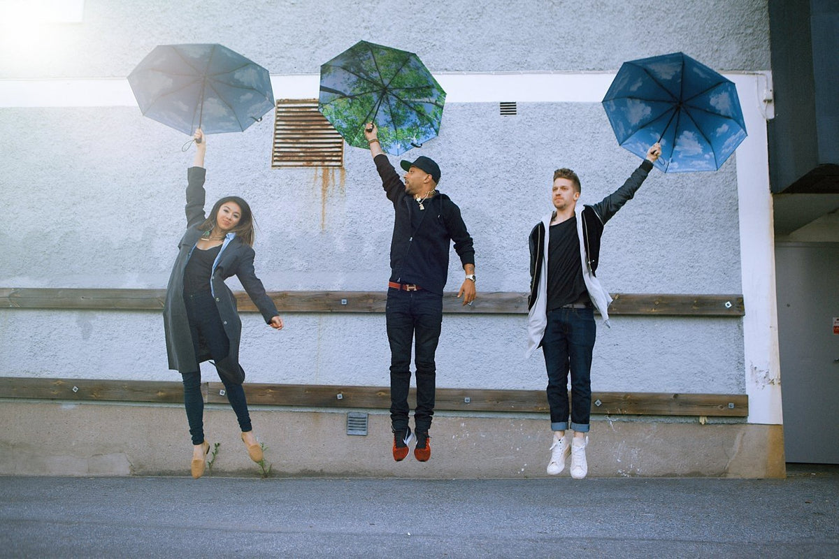 13. Three people jumping with Sky Lake umbrellas, showcasing windproof design