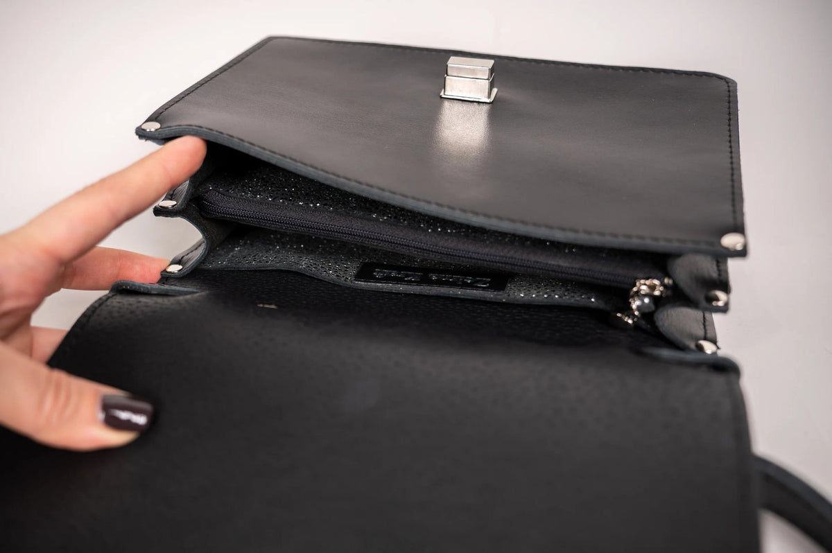 4. Interior view of Zelma Kraft black handbag showing compartments and Zelma Kraft branding