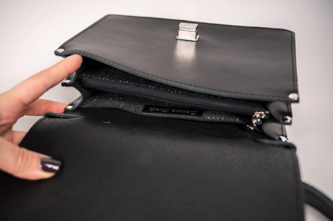4. Interior view of Zelma Kraft black handbag showing compartments and Zelma Kraft branding