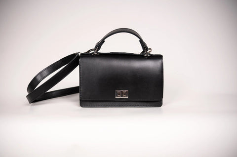 2. Studio shot of Zelma Kraft black small briefcase handbag with silver clasp and adjustable strap