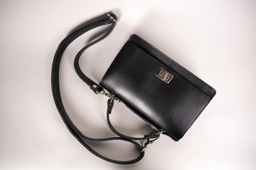 5. Flat lay of Zelma Kraft black small briefcase handbag with adjustable strap and silver clasp
