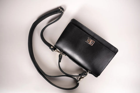 5. Flat lay of Zelma Kraft black small briefcase handbag with adjustable strap and silver clasp