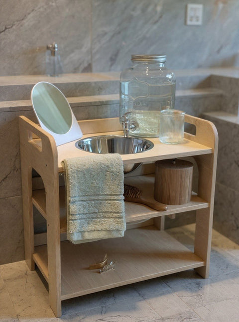 2. Montessori wash station with enamel bowl and towel in marble bathroom
