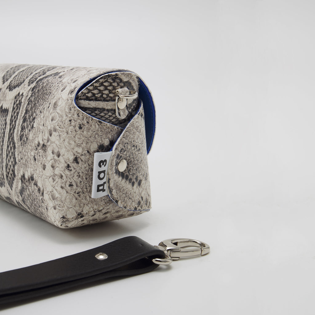 8. Side view of Daz Studio snake print leather bag with brand tag and detachable strap