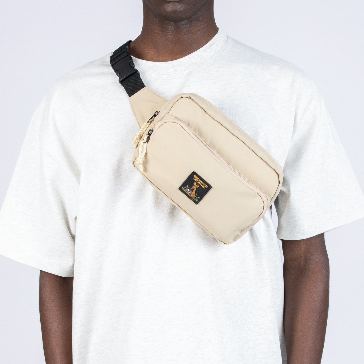 1. Man wearing beige Sniff Retro Waist Bag by Moomin across chest, casual outfit