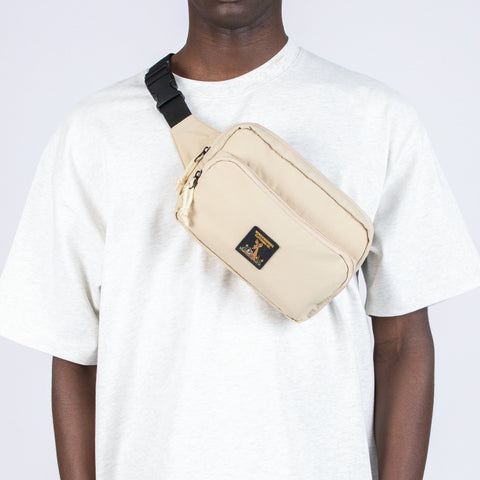 1. Man wearing beige Sniff Retro Waist Bag by Moomin NordicBuddies across chest, casual white shirt