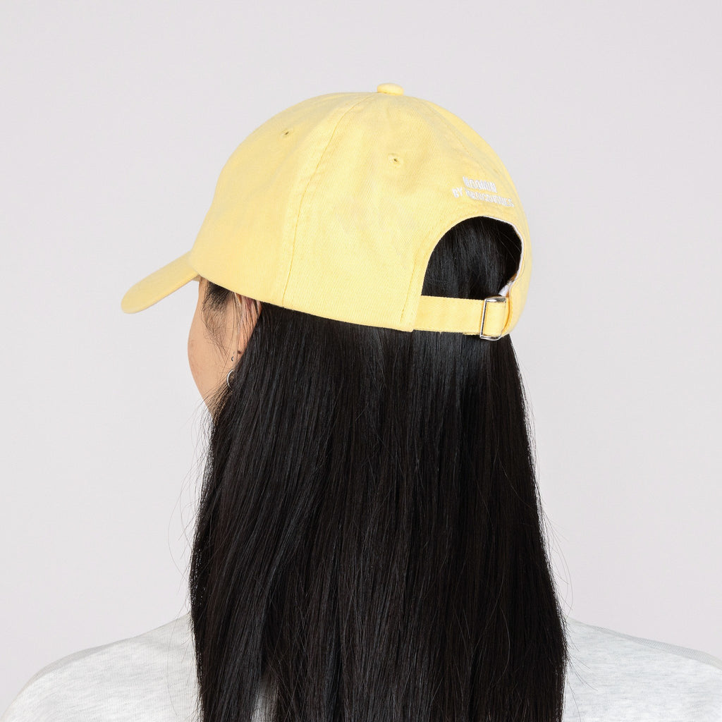 2. Woman wearing Moomin by NordicBuddies Snorkmaiden Dad Cap in yellow, back view