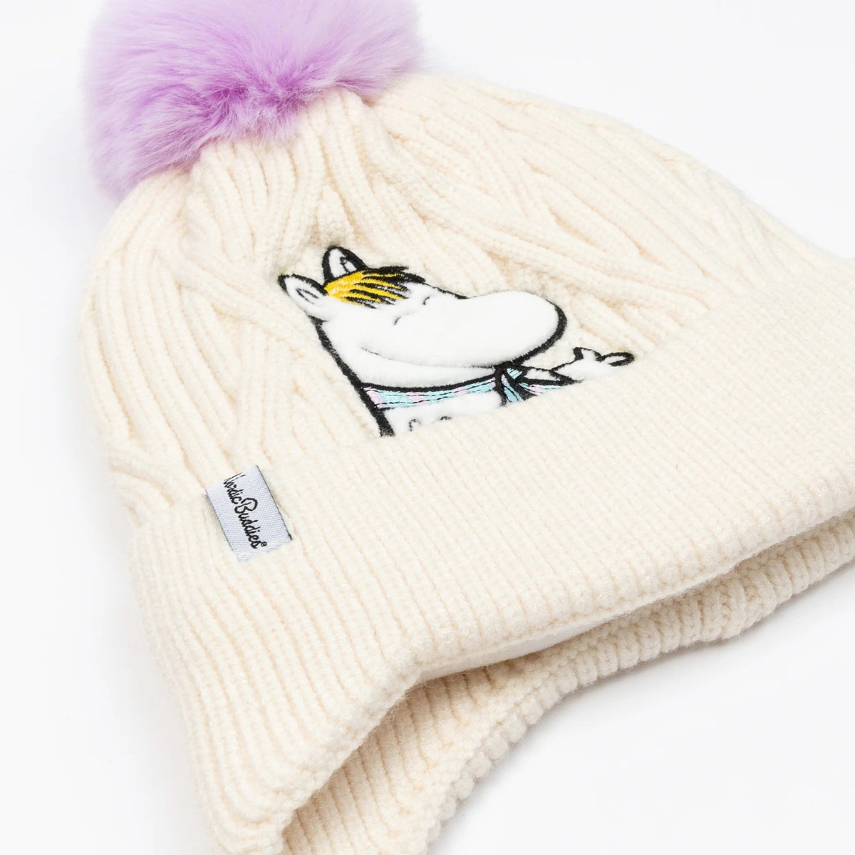 4. Flat lay of cream Snorkmaiden beanie with purple pom-pom and Moomin character embroidery, showing NordicBuddies label