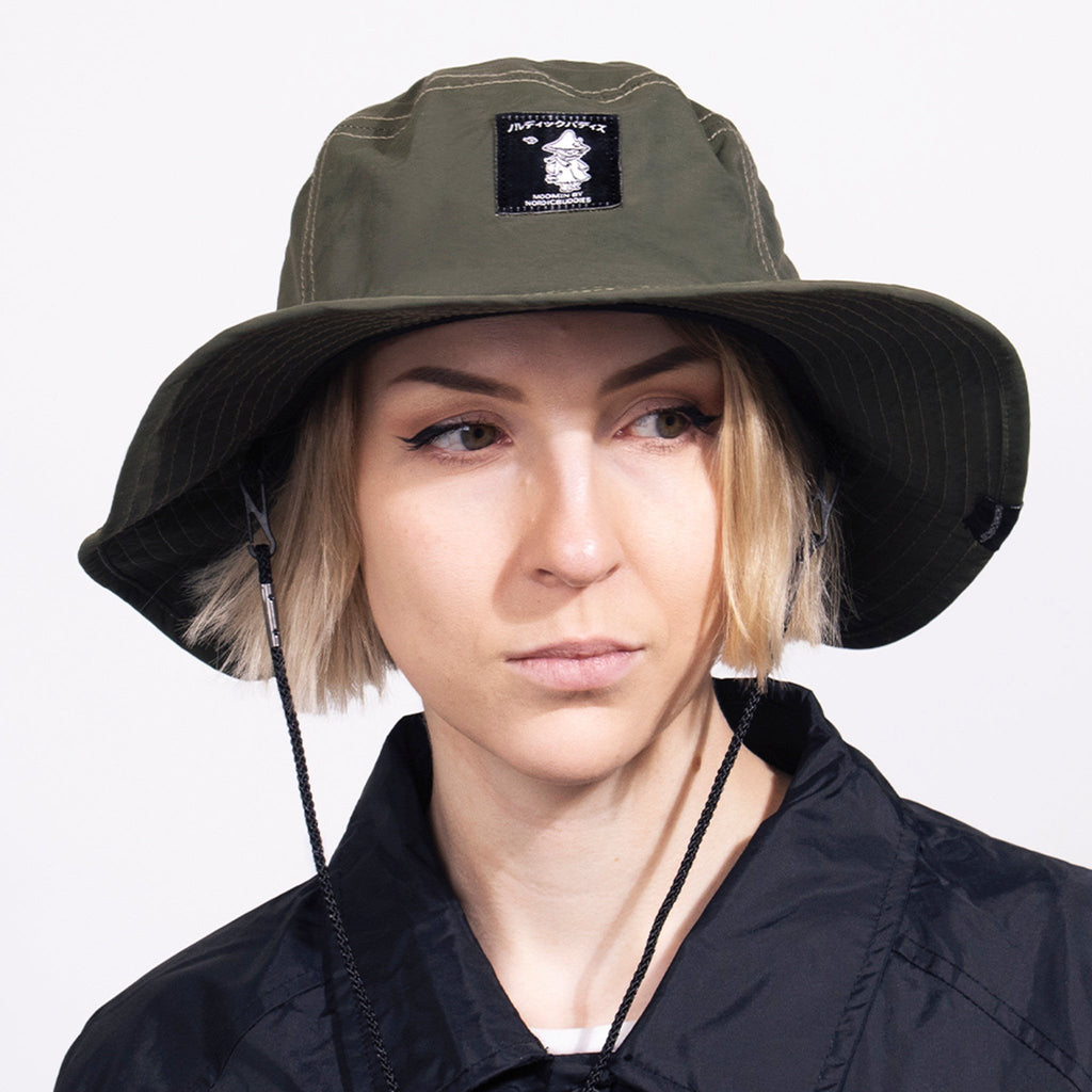 1. Woman wearing Snufkin Brimmer Hat in green by Moomin, showcasing front view with logo patch