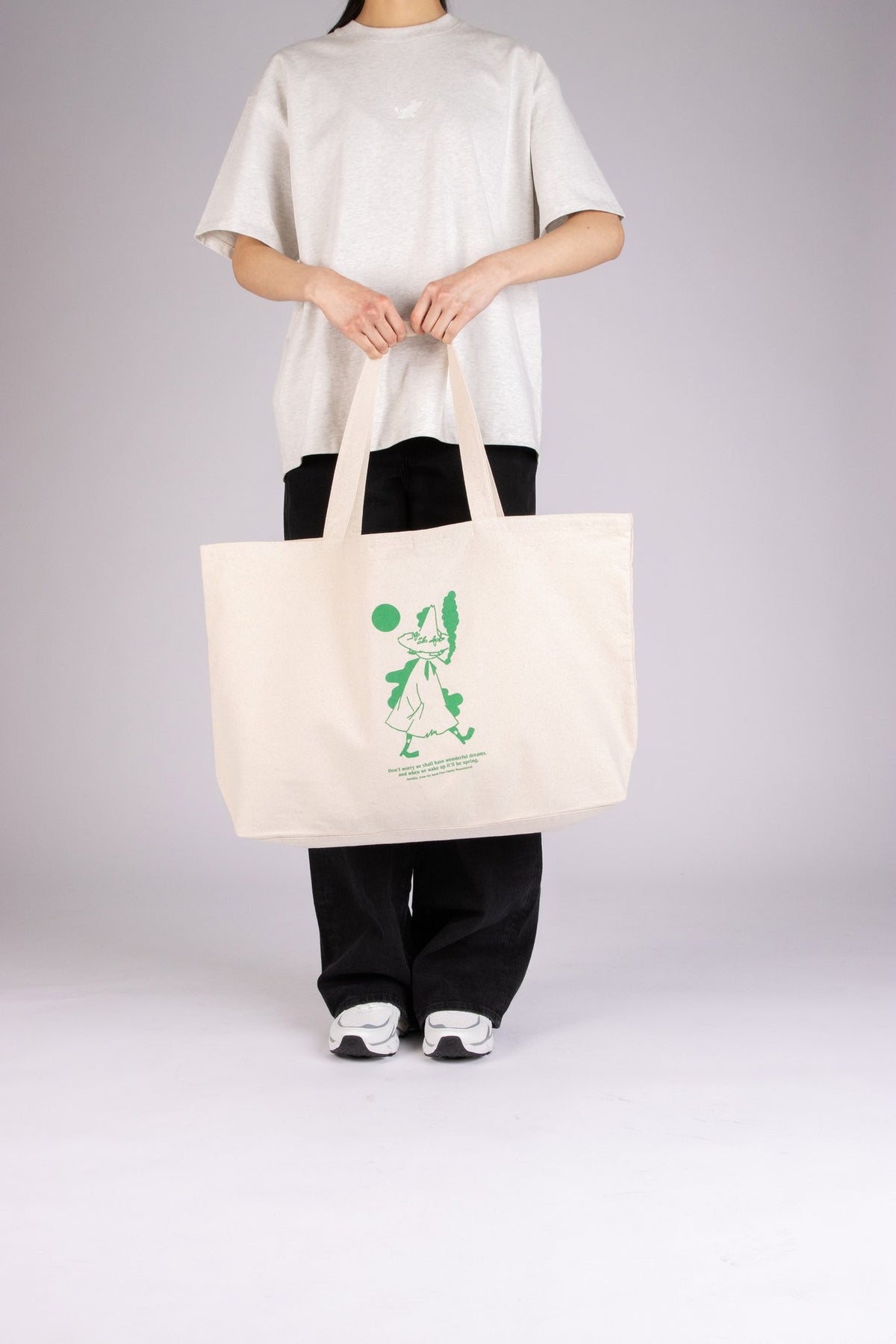 2. Female model showcasing Moomin by NordicBuddies Snufkin XXL tote bag in studio