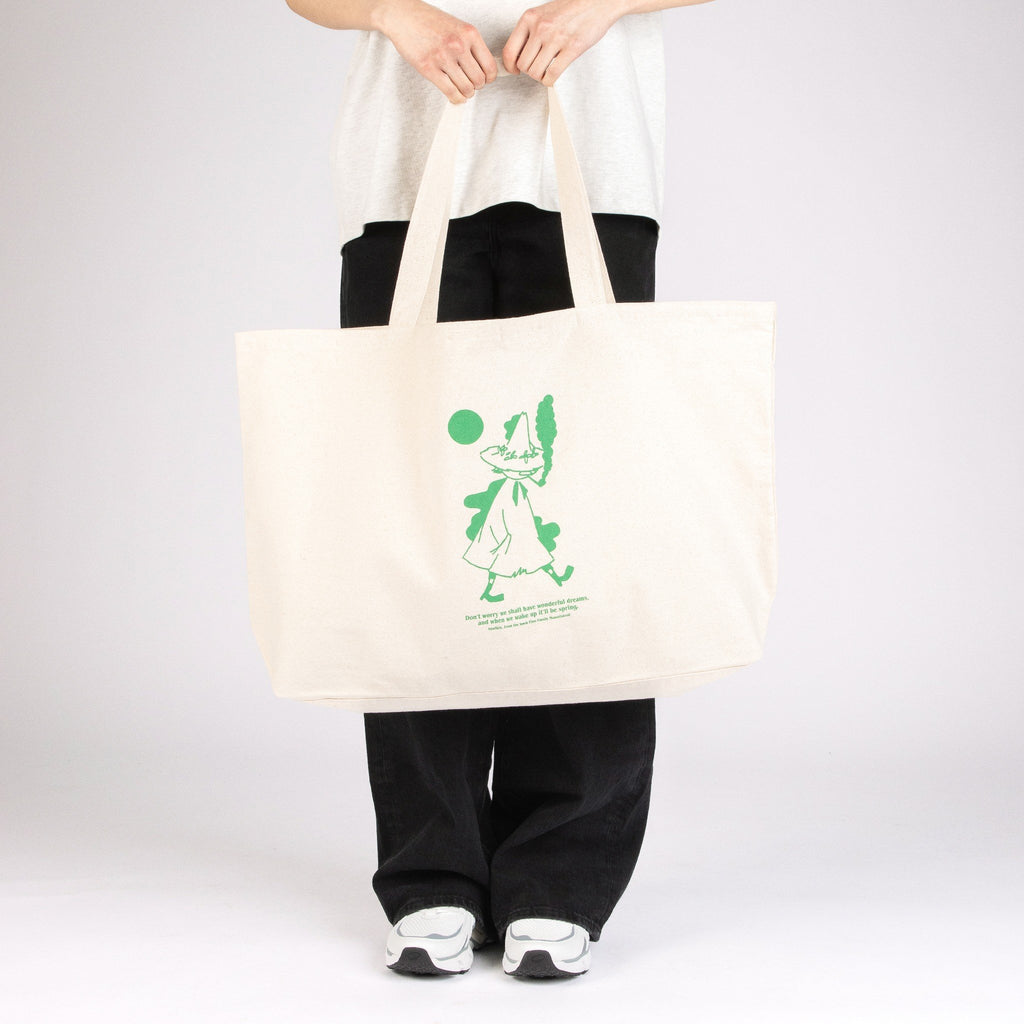 1. Woman holding Moomin by NordicBuddies Snufkin XXL tote bag in studio setting