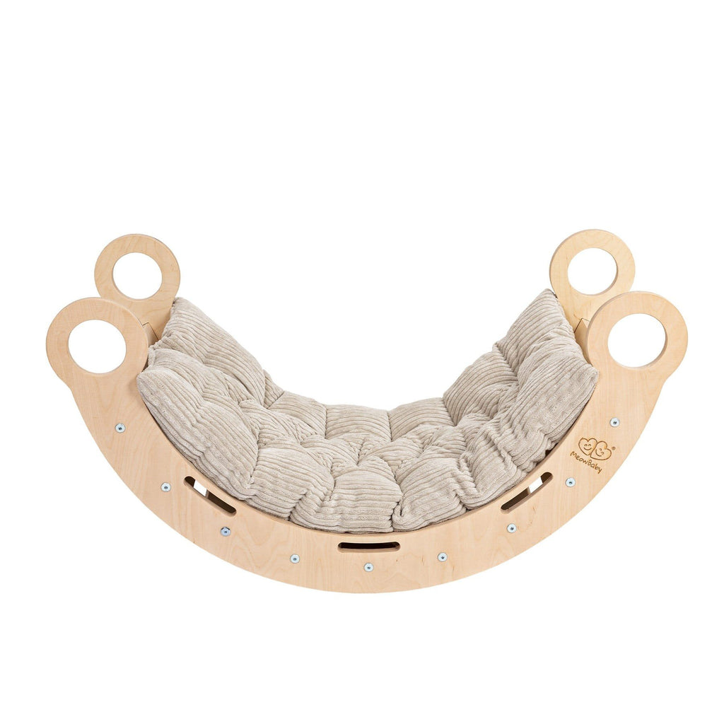1. Snug Rocker for kids in natural birch plywood with beige cushioned pillow, featuring rounded edges and handles, shown in a studio setting
