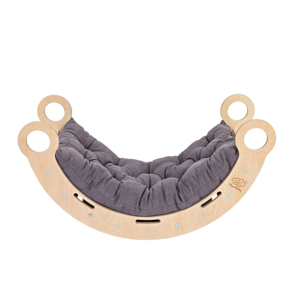 1. Snug Rocker for kids in natural birch plywood with grey pillow, featuring rounded edges and handles, shown in a studio setting