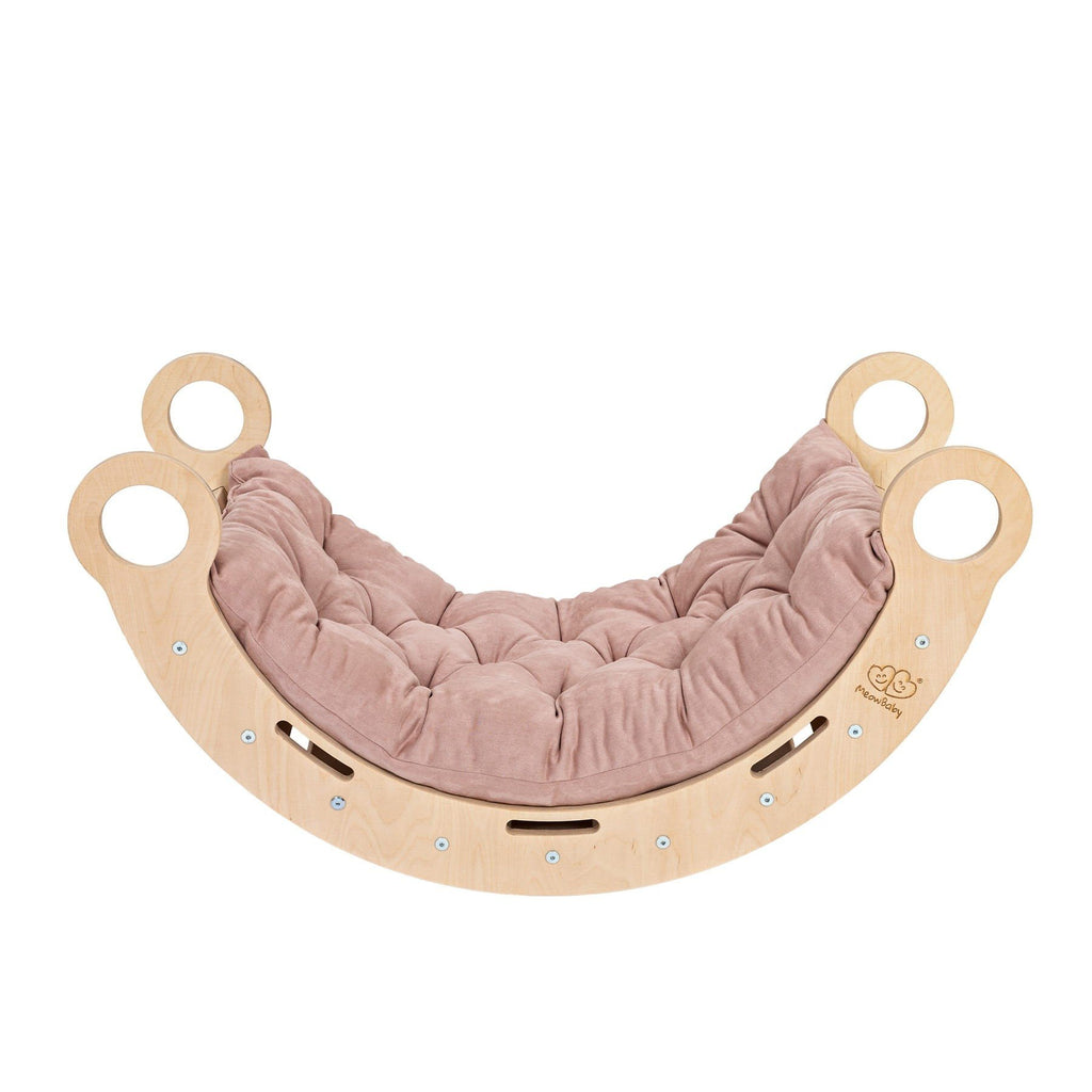 1. Snug Rocker for kids in natural birch plywood with pink pillow, featuring rounded edges and handles, shown in a studio setting