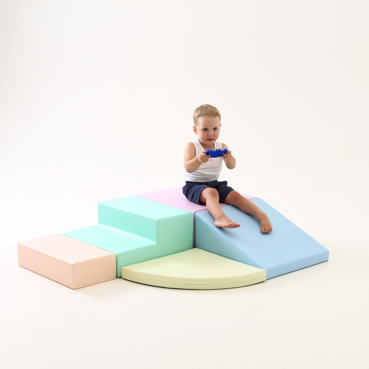 14. Boy playing on IGLU pastel foam block set with steps and ramp in a studio