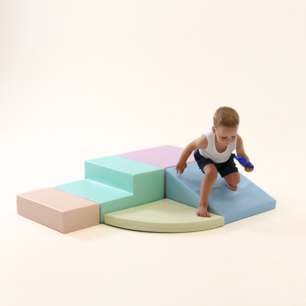 9. Boy climbing on IGLU pastel foam block set with steps and ramp in a playroom
