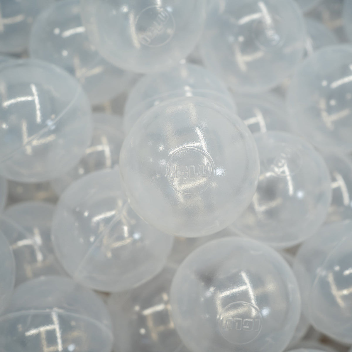 1. Close-up of translucent IGLU soft play ball pit balls with logo, showing smooth texture and durable design