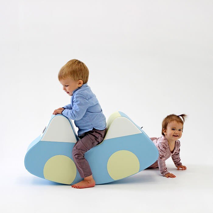 6. Two toddlers playing with light blue soft play ride-on toy car, one sitting and one crawling, on white background