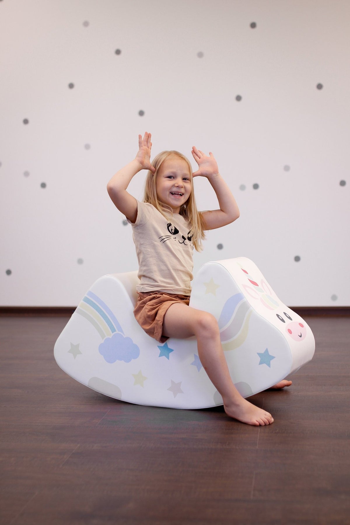 10. Girl playing on IGLU unicorn ride-on toy in a playroom setting, enhancing social skills