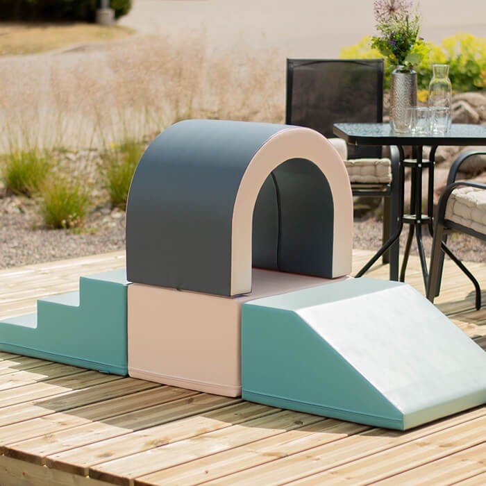1. Outdoor setting with IGLU pastel soft play tunnel set on wooden deck, featuring steps and ramp