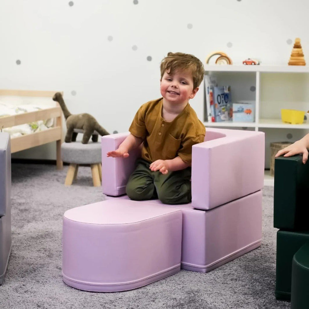 1. Child playing on pink IGLU Snoozy soft play sofa chair in a playroom