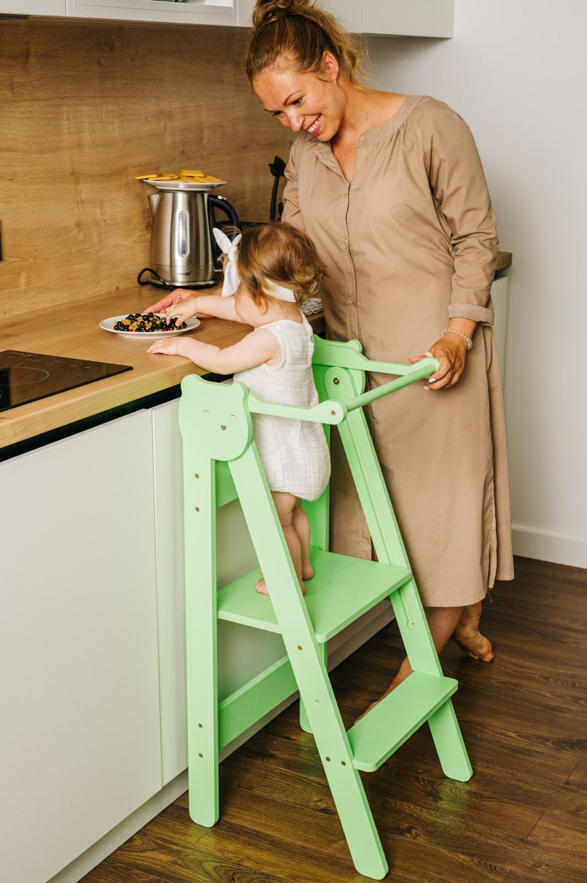 5. Woman and child using green step stool in kitchen