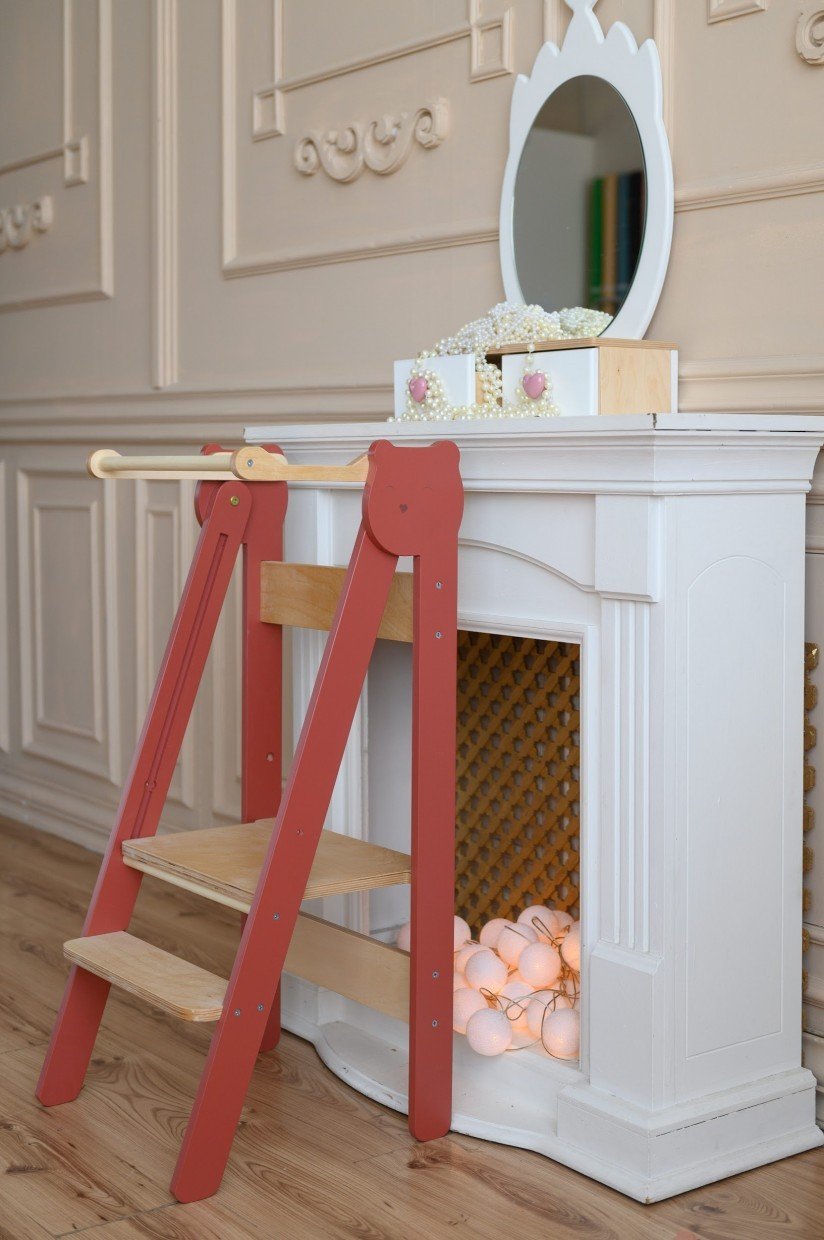 20. Red step stool against white vanity in elegant room