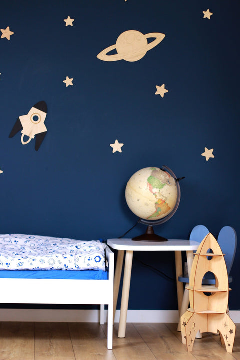 2. Space-themed children's room with wooden Saturn, rocket, and stars on dark blue wall