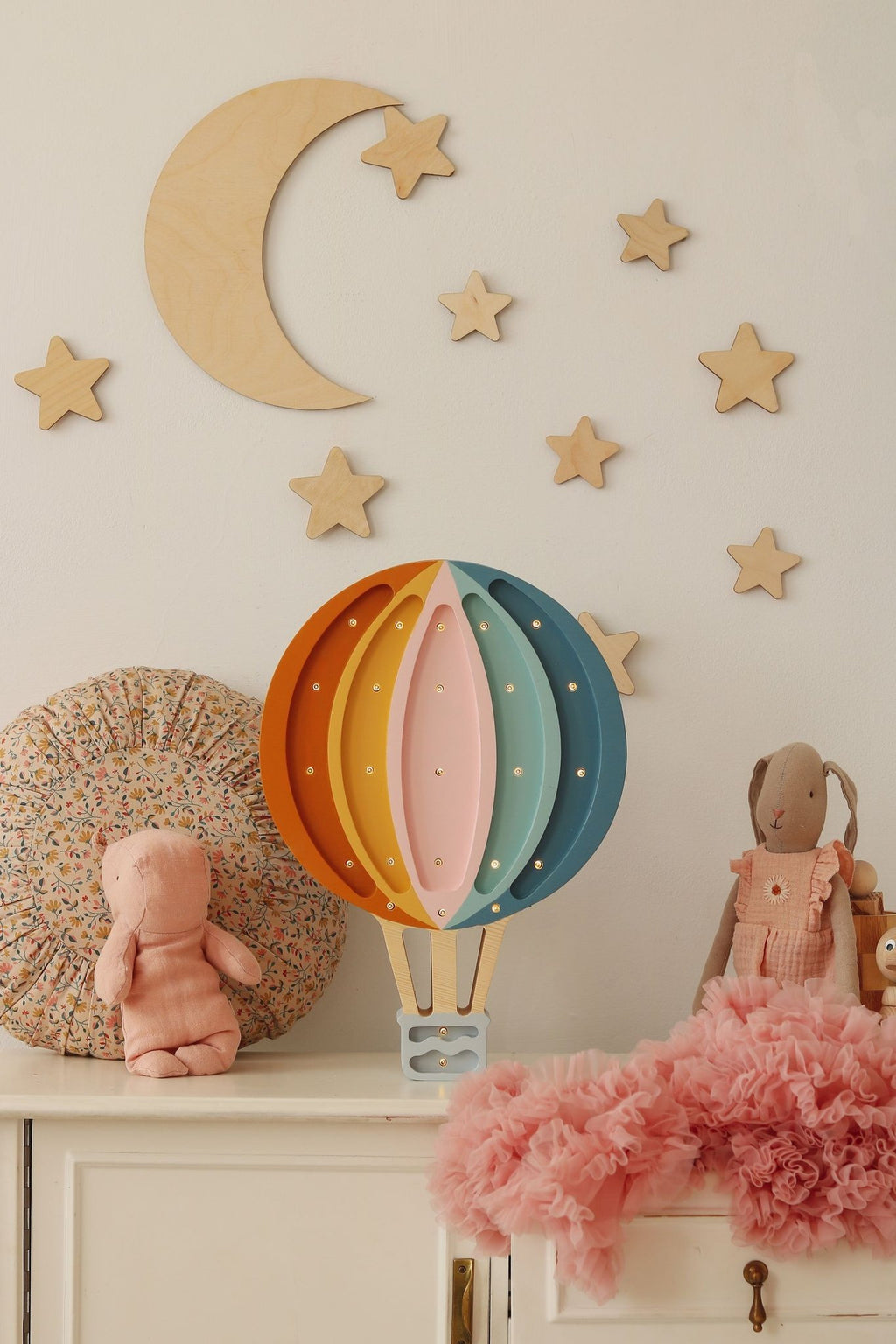 6. Children's room with wooden moon and stars above cabinet with colorful hot air balloon lamp