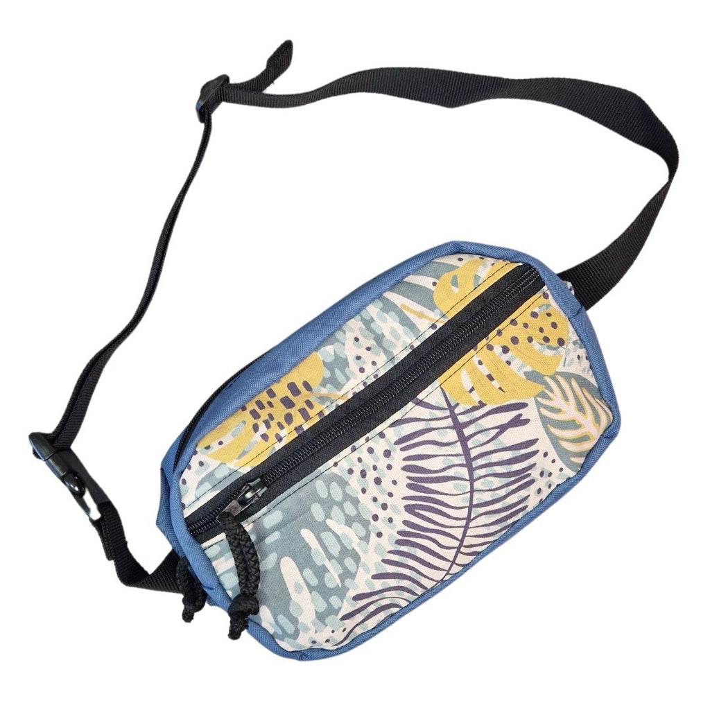 2. Studio shot of Drinbags spacious water-resistant waist bag in blue with tropical print, angled view showing strap