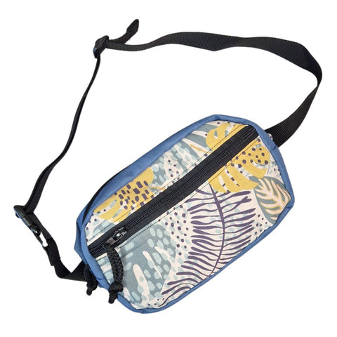 2. Studio shot of Drinbags spacious water-resistant waist bag in blue with tropical print, angled view showing strap