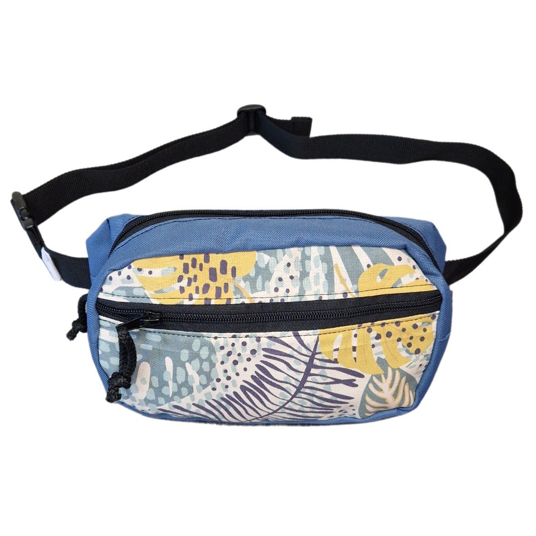 2. Studio shot of Drinbags spacious water-resistant waist bag in blue with tropical print, showing front pocket and adjustable strap