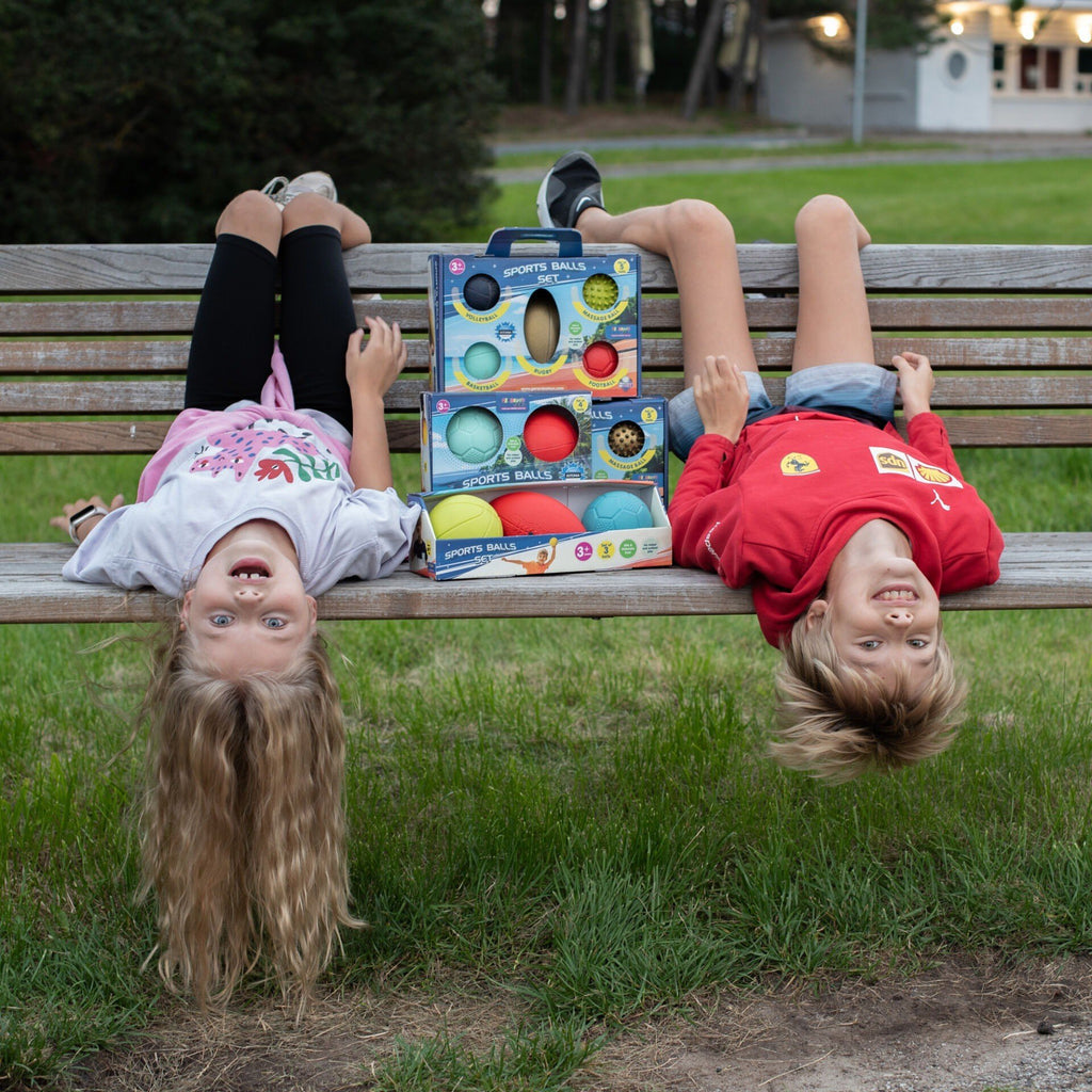 1. Two children upside down on a bench with Gerardo's Toys sports balls set in a park