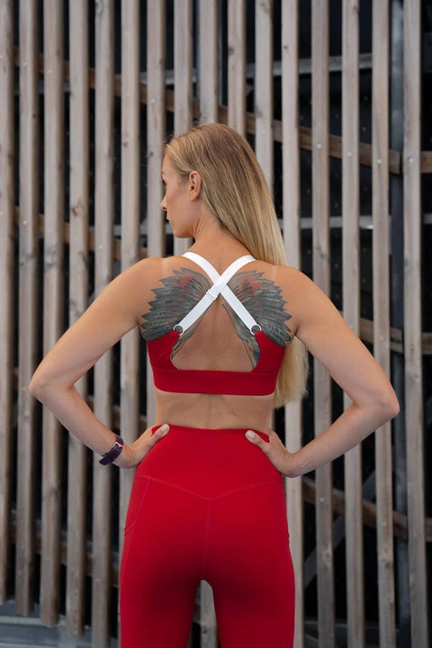 2. Back view of woman wearing Peachlabel 'Cute Cranberry' red sports bra with crisscross straps