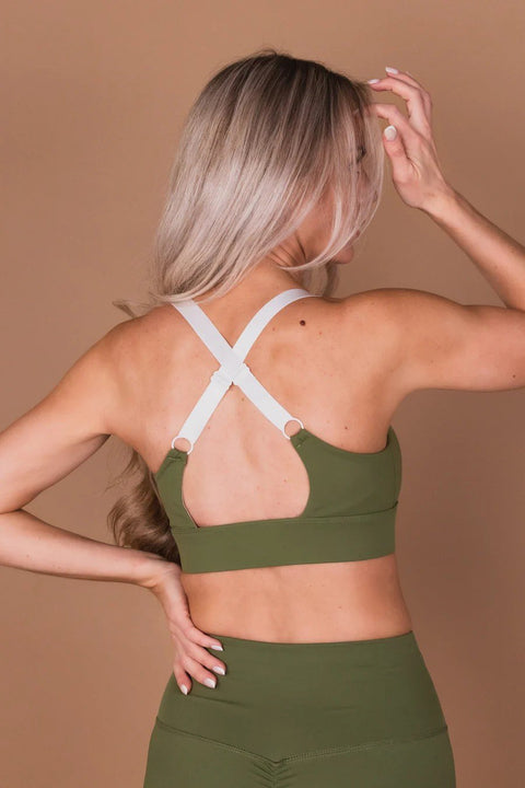 4. Back view of Peachlabel Olive Green Sports Bra showing adjustable straps and elastic band, studio setting