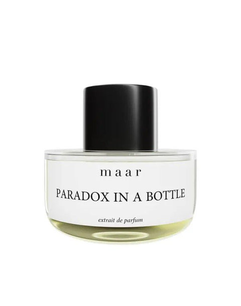 2. Round glass bottle of maar Paradox In A Bottle perfume with black cap, showcasing minimalist label