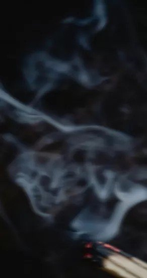 6. Wisps of smoke against a dark background, illustrating the mysterious scent note