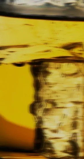 8. Close-up of golden liquid, capturing the rich color and reflective surface