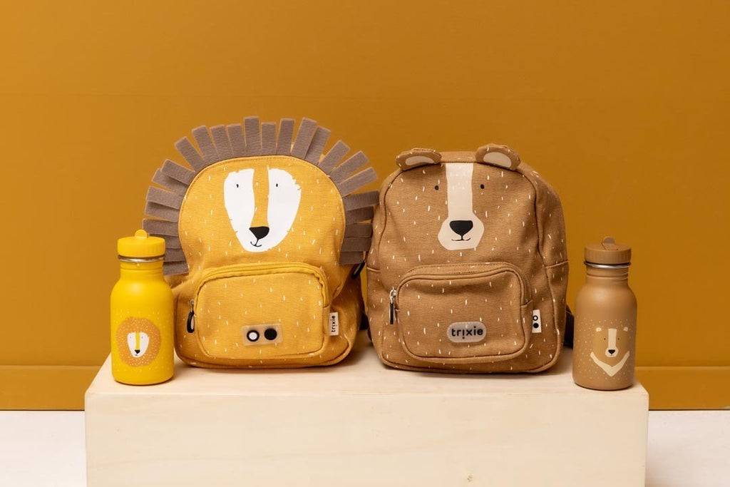 4. Trixie Baby Mr. Bear and Lion backpacks with matching stainless steel bottles on wooden surface