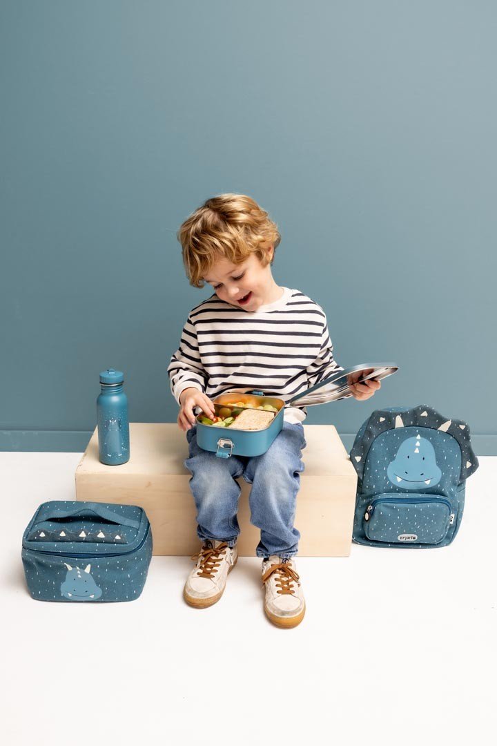 9. Child sitting with blue Mr. Triceratops bottle and matching lunch accessories, wearing striped shirt and jeans