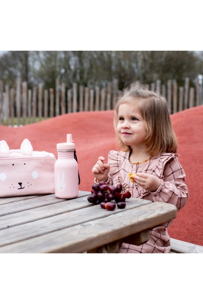 1. Young girl sitting at picnic table with pink bunny design stainless steel bottle and matching lunch bag