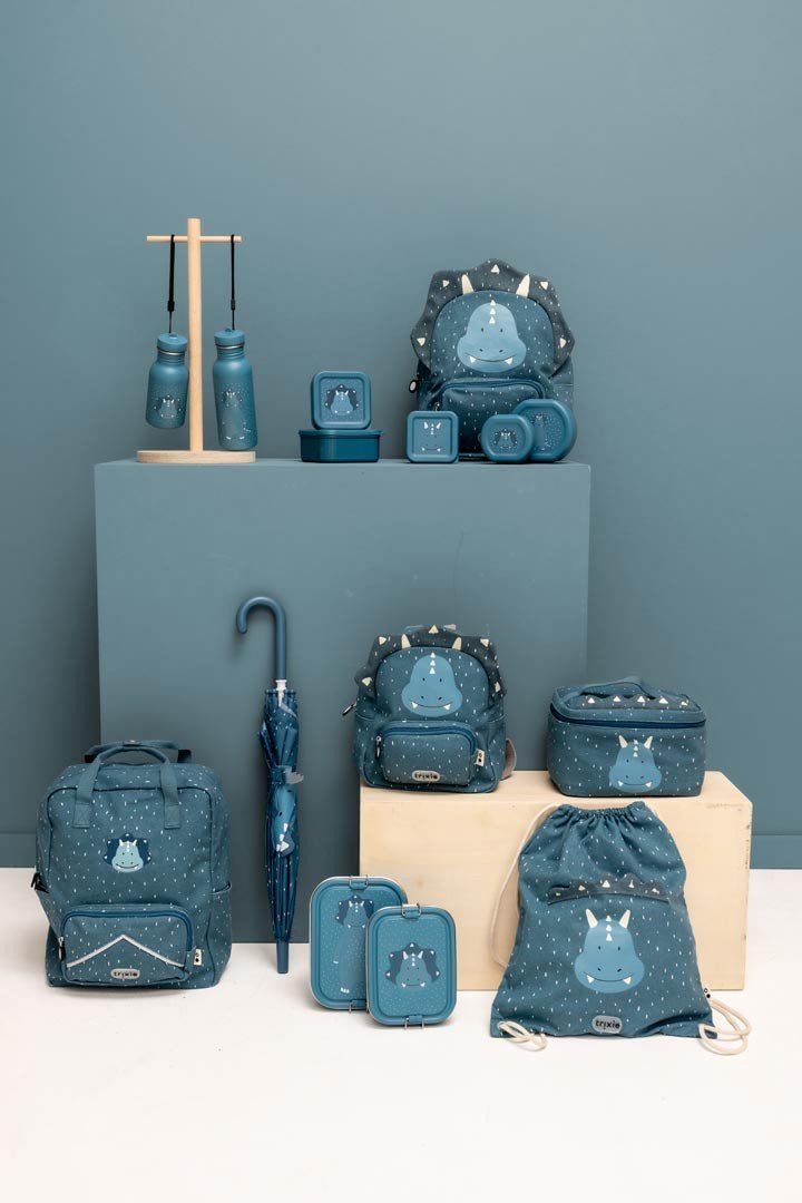 9. Collection of blue Mr. Triceratops themed items including bottles, backpacks, and lunchboxes on display against a blue background