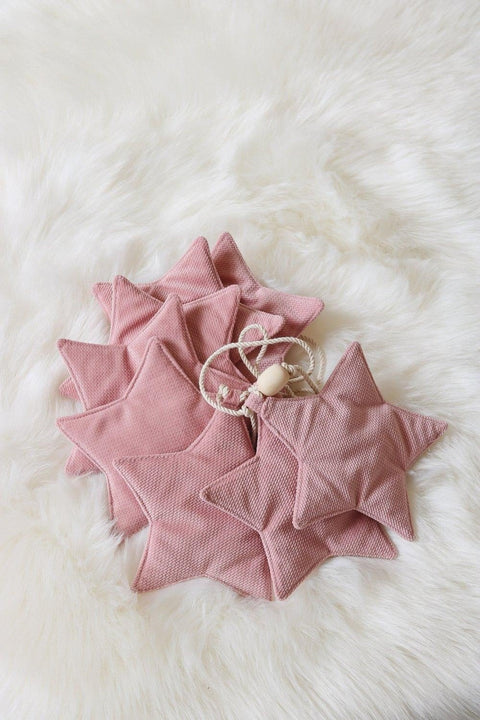 4. Flat lay of soft pink velvet star garland on fluffy white background