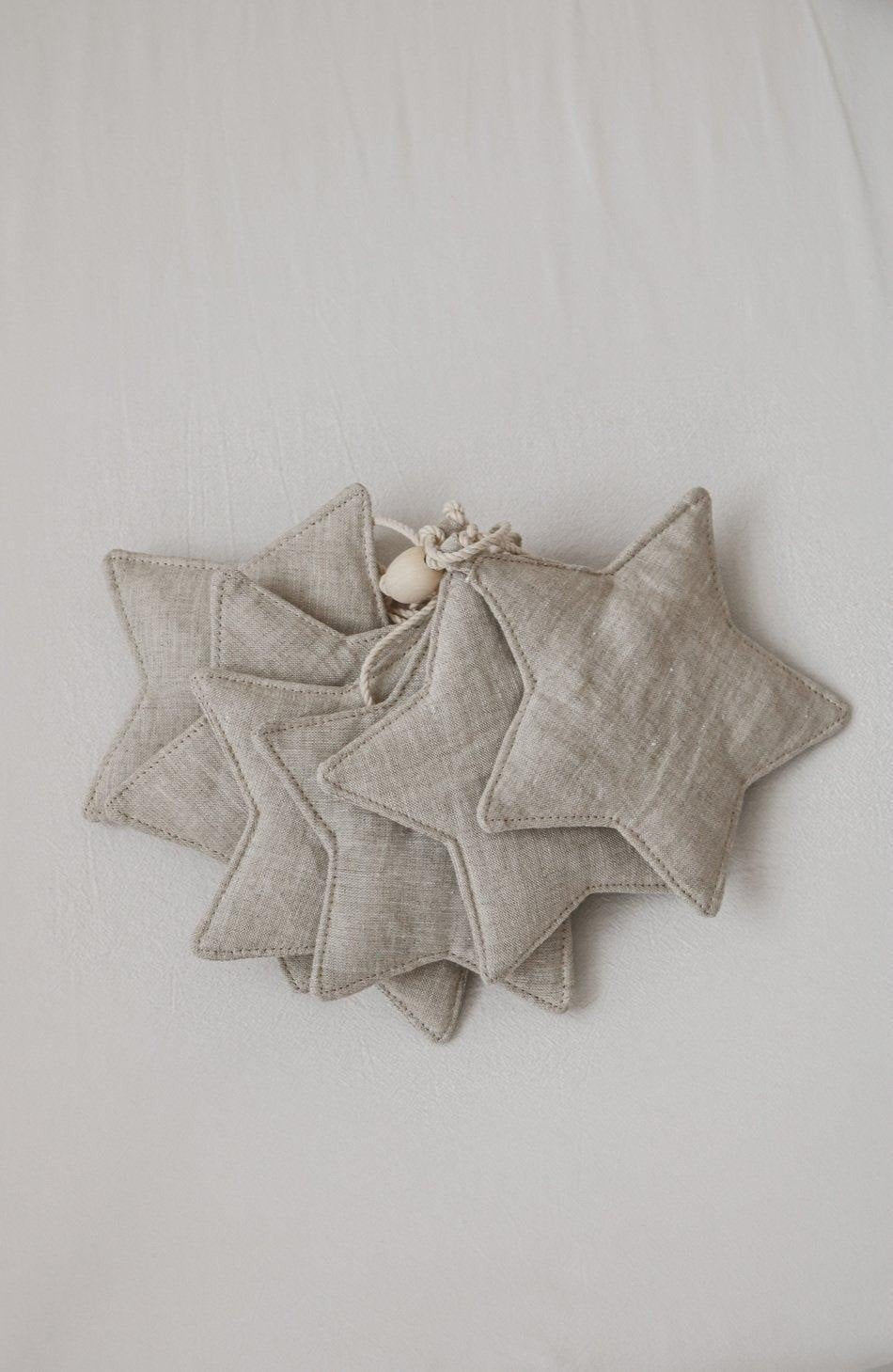 4. Flat lay of linen star garland with wooden beads on light fabric background